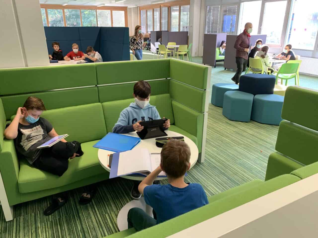 Schüler*innen betreiben eigenständiges digitales Lernen im PerLenWerk an der RGS Marburg. Es gibt viele Gruppen Tische und es ist gemütlich.